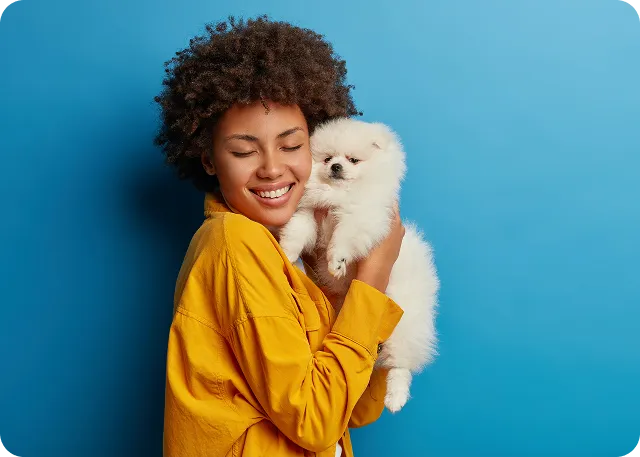 Mulher segurando um cachorro branco